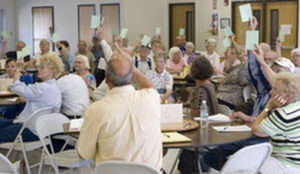people sitting at tables and voting